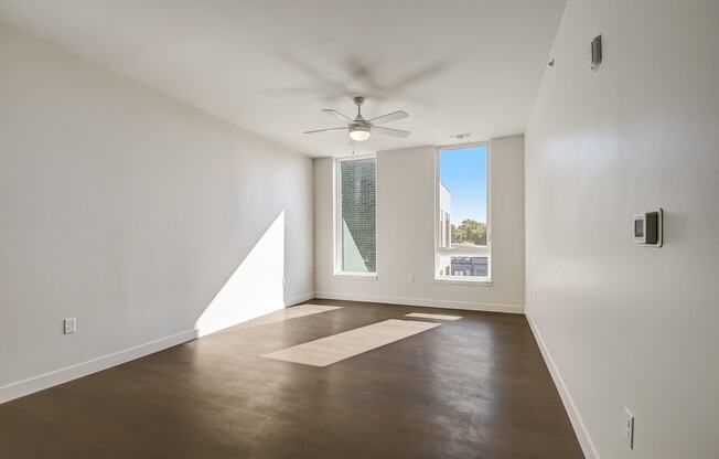 a living room with white walls and a large window