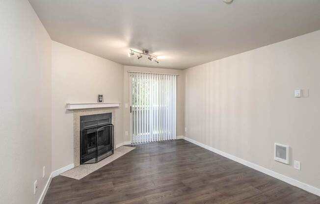 Living room with fireplace and sliding glass doors at Quartz Creek Apartments in Mountlake Terrace, WA
