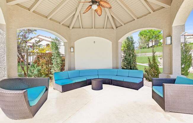 a covered patio with a blue couch and chairs