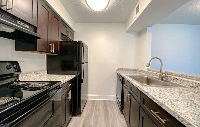 Modern kitchen with faux wood flooring at Camelot East Apartments, Fairfield, OH