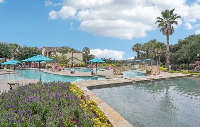 a swimming pool with umbrellas at the resort at The Verandah, Austin