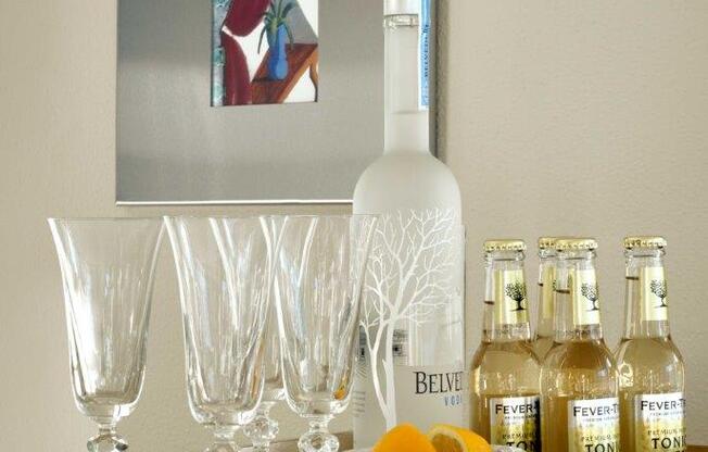 A bottle of Belvedere vodka is on a counter with glasses and bottles of Fever tree tonic water.