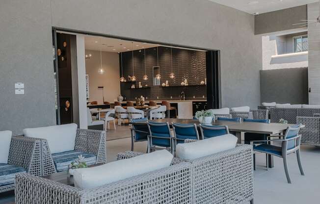 A modern outdoor seating area with white and blue wicker furniture.