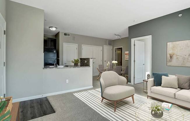 A living room with a grey carpet and a striped rug.