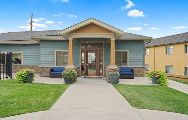 A building with a blue and yellow exterior and a brown door at Mountain Vista Apartments, Lakewood, CO