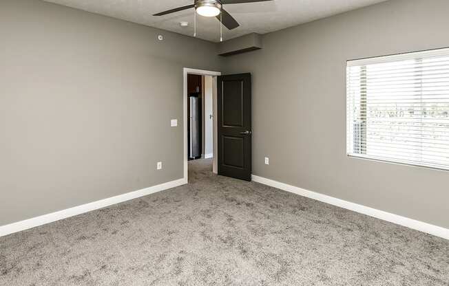 A room with a ceiling fan and a carpeted floor.