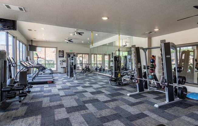A spacious gym with a variety of equipment and a checkered floor.