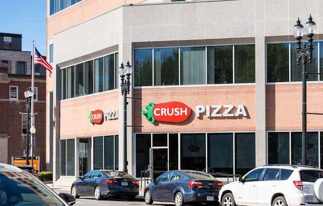 A Crush Pizza restaurant with cars parked in front.