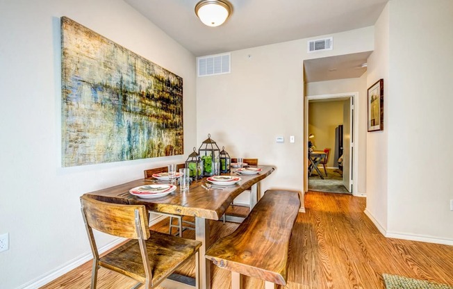 a dining room with a table and chairs and a painting on the wall at Villa Espada Apartments, Texas