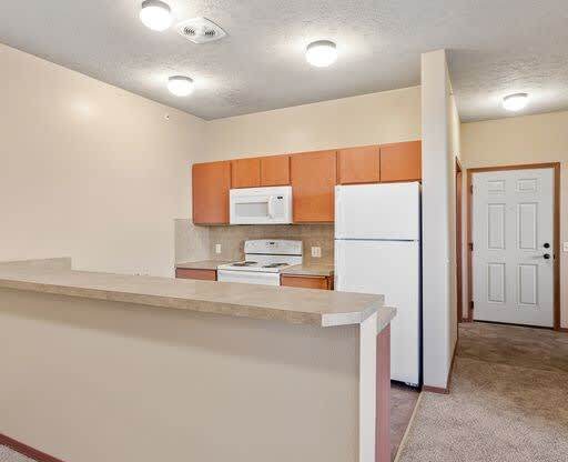 a kitchen with a white refrigerator freezer next to a stove top oven