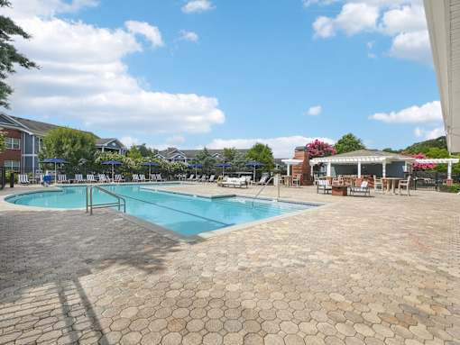 Resort-style apartment pool and outdoor lounge spaces at Village at Broadstone Station in Apex, NC