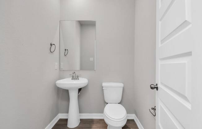 a bathroom with a toilet sink and mirror