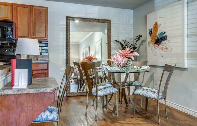 A kitchen with a dining table and chairs.