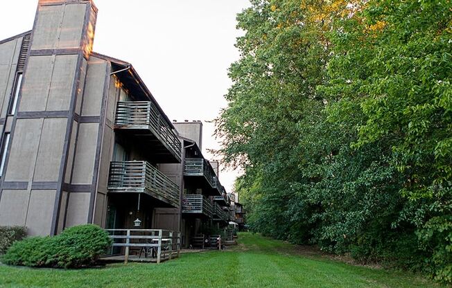 the exterior of a building with a lawn and trees