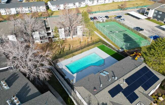 an aerial view of a house with a swimming pool and tennis court