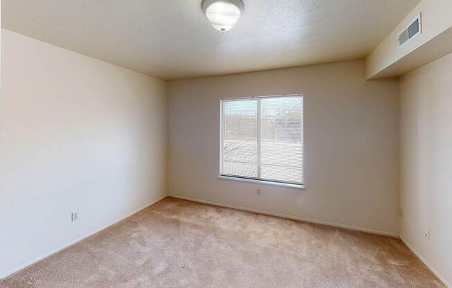 A bedroom with a window and carpeted floor at Foxwood and The Hermitage, Portage, MI