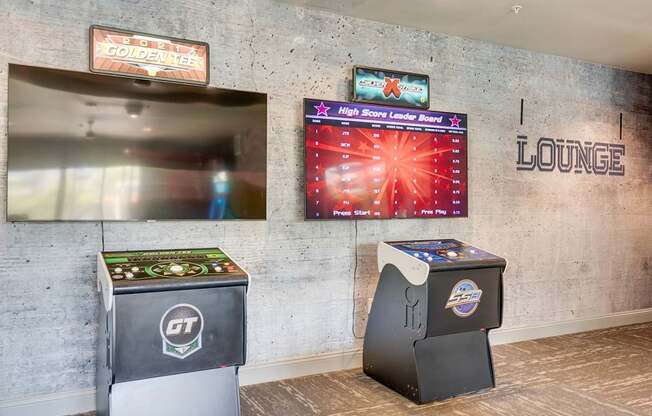 A lounge area with a high score leaderboard and two arcade machines.
