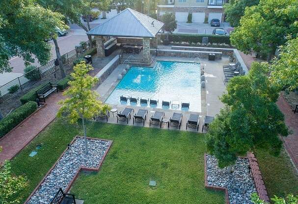 an aerial view of a swimming pool and a lawn with chairs