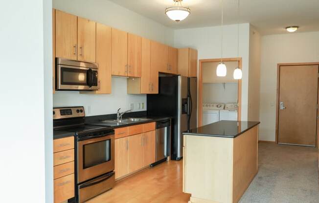 A kitchen with wooden cabinets and black appliances.