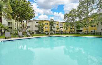 a swimming pool with an apartment building in the background