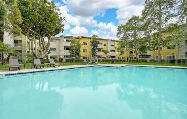 a swimming pool with an apartment building in the background