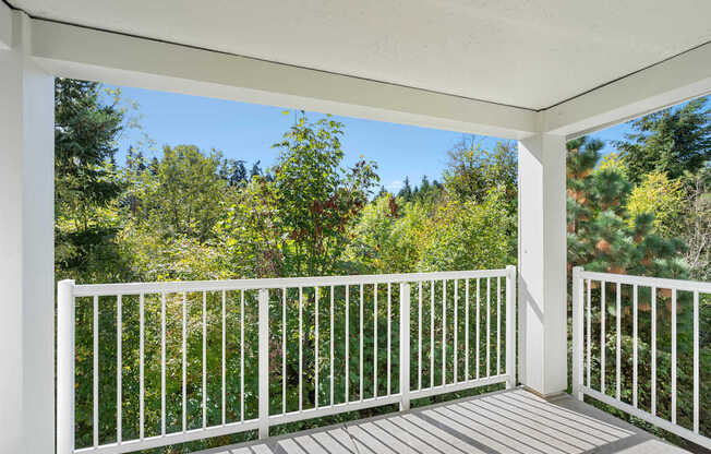 the view from the deck of a home with a view of trees