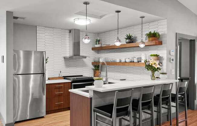 a kitchen with a white counter top and a stainless steel refrigerator