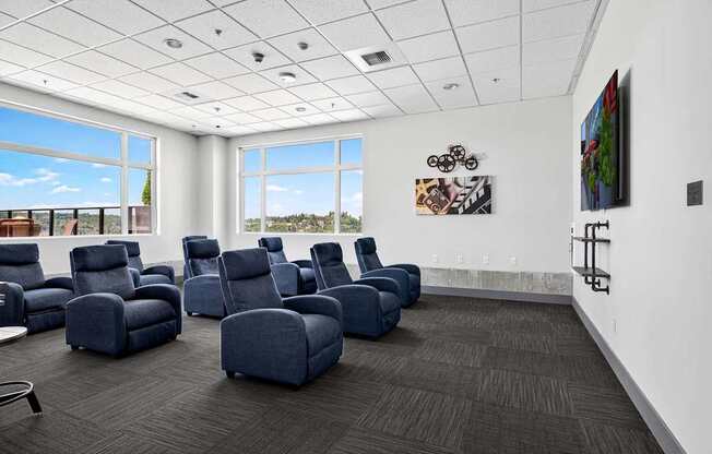 A room with blue chairs and a painting on the wall.