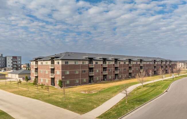 A large apartment complex with a road in front of it.