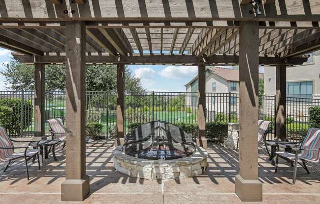 a patio with chairs and a fire pit