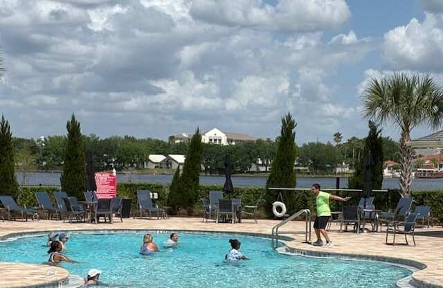 A group of people are enjoying a swim in a pool on a sunny day.