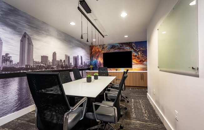a meeting room with a large screen tv and a long table with chairs