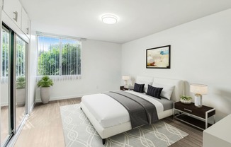 a white bedroom with a bed and a sliding glass door