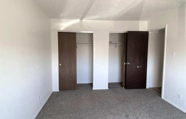 A room with two doors and carpeted floor.