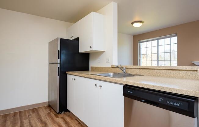 a kitchen with a sink and a black refrigerator