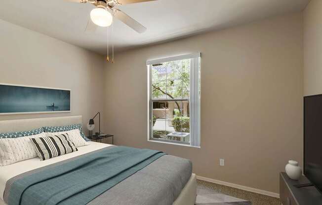 A bedroom with a bed, a ceiling fan, and a window.