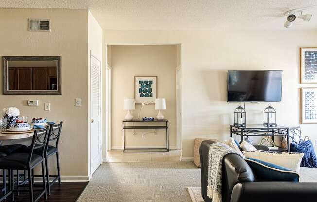 a living room with a tv and a table with chairs