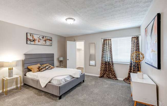 a bedroom with a bed and a window with curtains