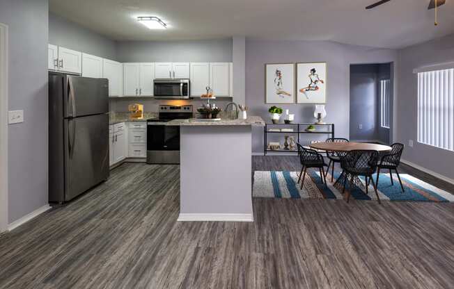 a kitchen with stainless steel appliances and a table and chairs