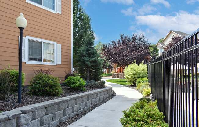 Walkway through apartment community in West Richland, WA surrounded by green plants.
