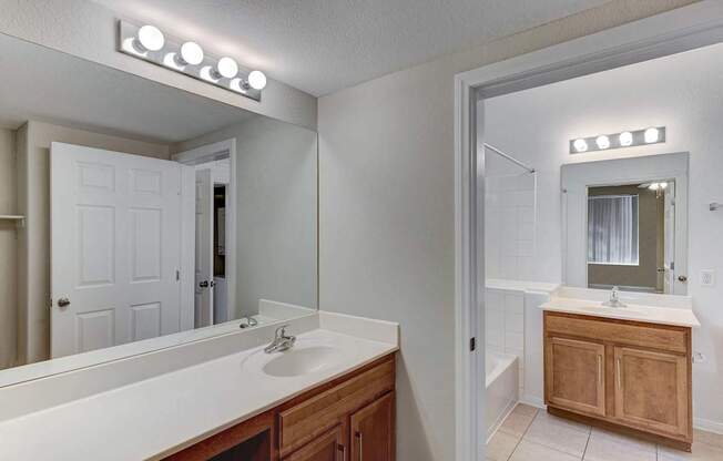 A bathroom with a white counter top and a white sink.