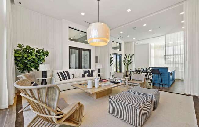 A modern living room with a striped ottoman and a wooden chair.