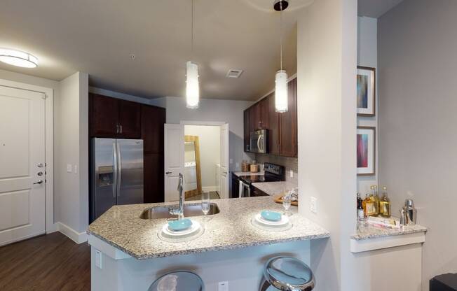 a kitchen with granite countertops and stainless steel appliances