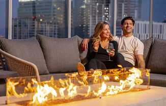 a man and woman sitting on a couch in front of a fireat AVE Phoenix Sky, Phoenix, Arizona