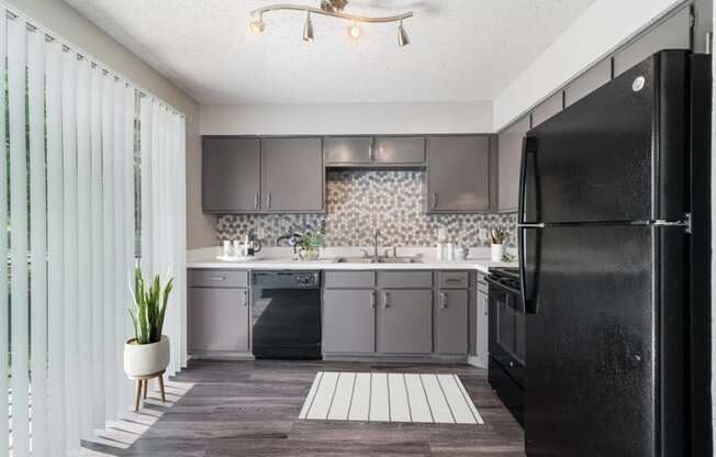 a kitchen with a black refrigerator and a sink  at Shadow Ridge, Texas, 76013