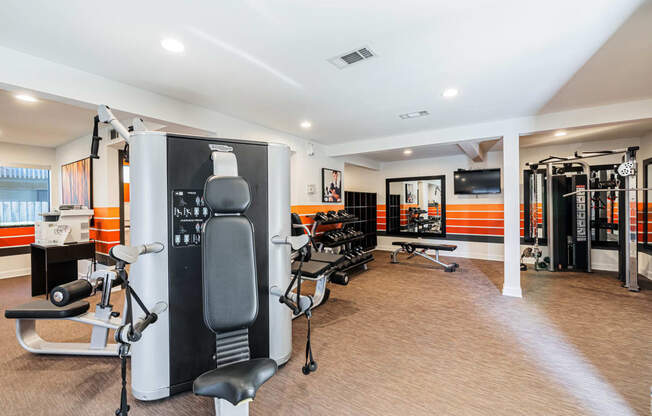 a gym with various machines and chairs in a room