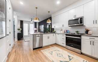 a large kitchen with white cabinets and stainless steel appliances