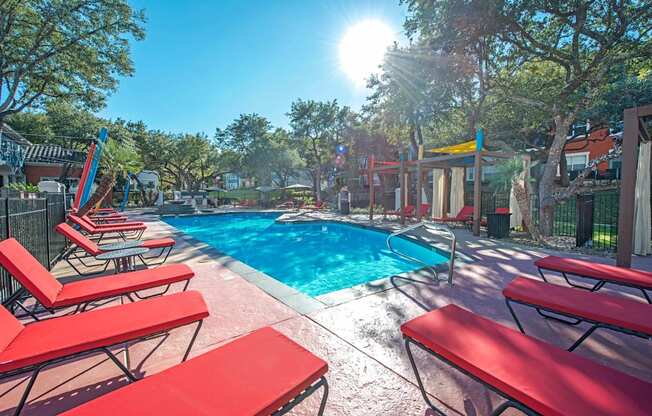 A sunny day at the pool with red sun loungers at Reserve at Canyon Creek, San Antonio,78230