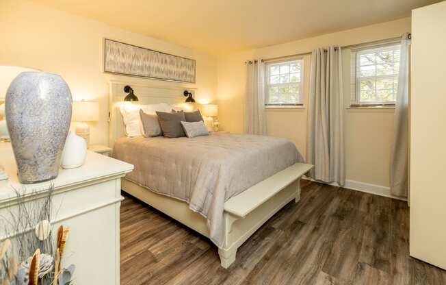 a bedroom with a bed and two windows