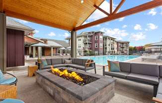 A patio with a fire pit and couches.